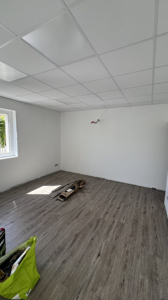 Bureaux rénovés avec cloisons en placo, peinture blanche et sol PVC à Corte